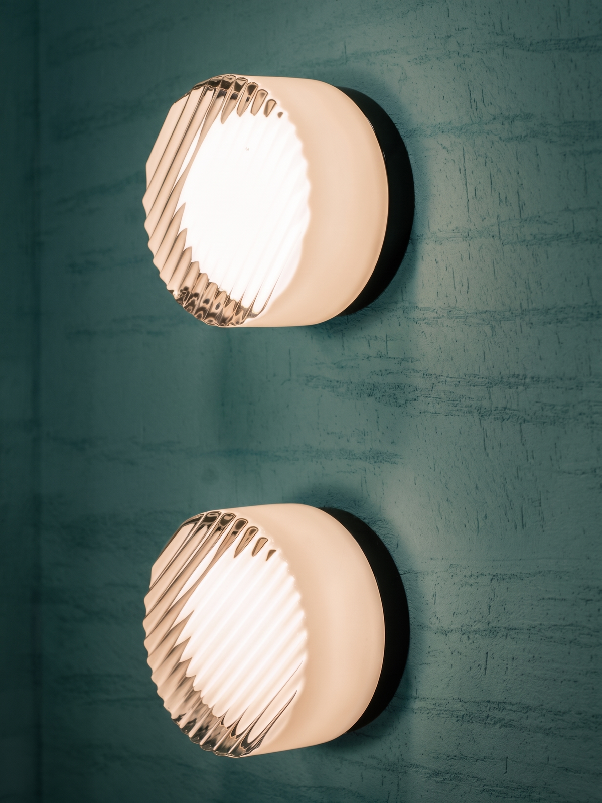 Pair of white ribbed Orla wall lights on a dark green wall