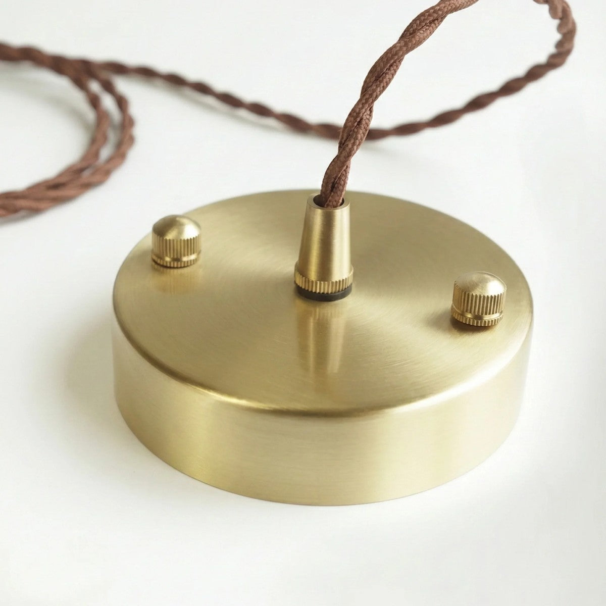 Brass ceiling canopy and twisted fabric cord of the Hana pendant light