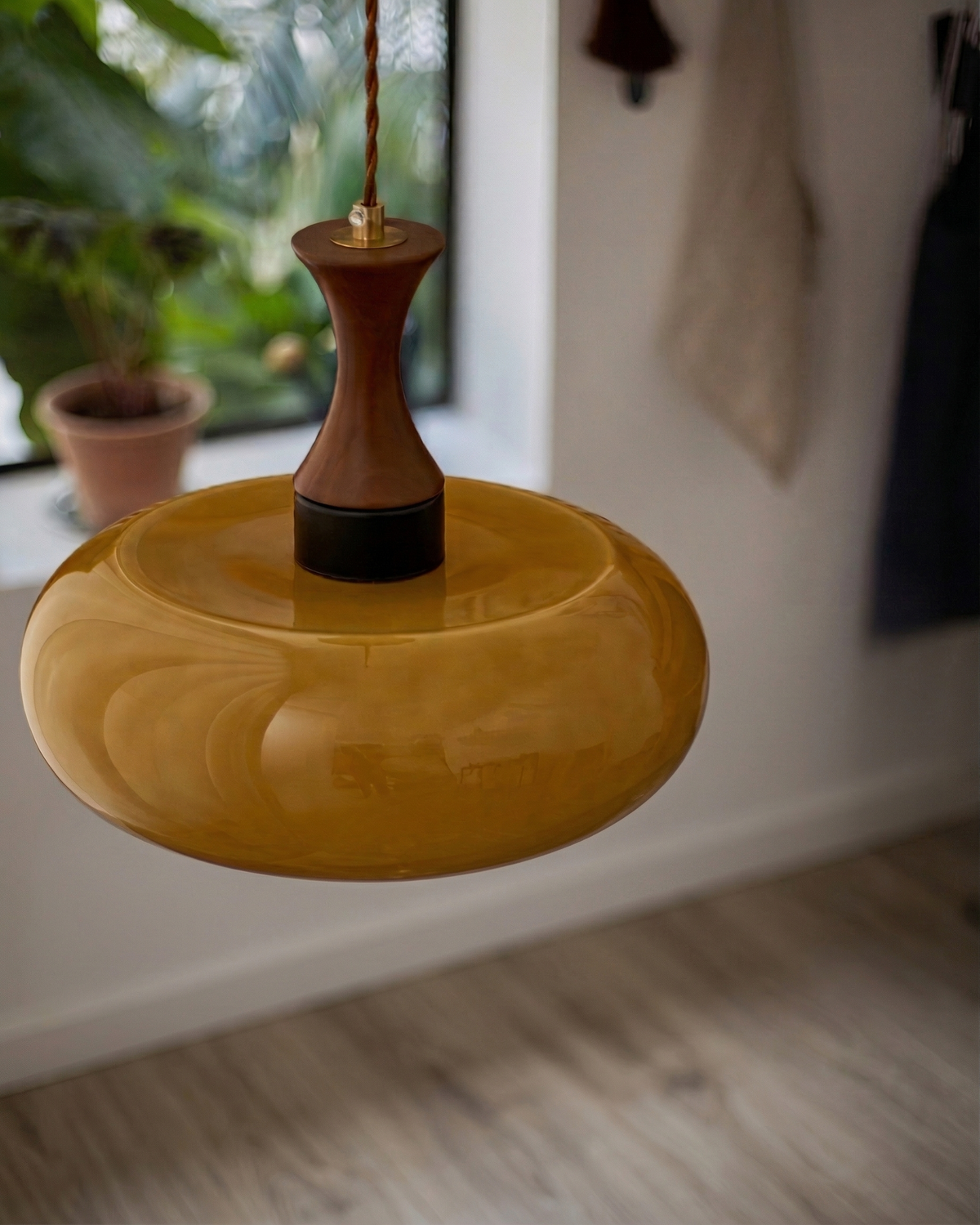 Detail of the Ovia amber glass saucer shade and wood neck