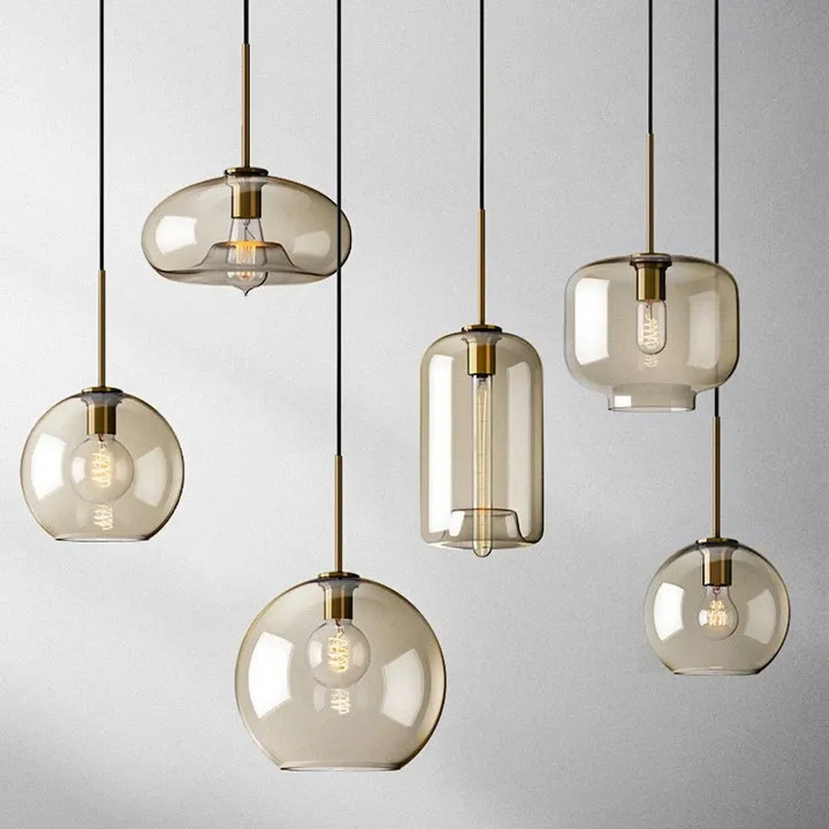 Ambra amber glass pendant lights in all five shapes: globe, large globe, jar, cylinder and oval, with brass stems