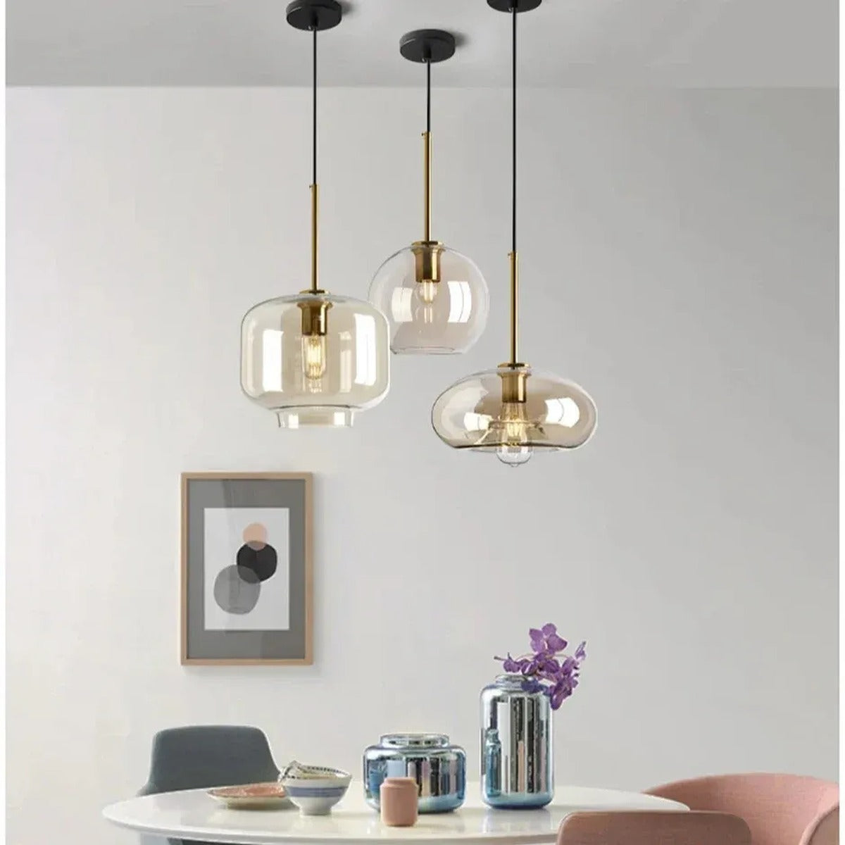 Ambra amber glass pendant lights in jar, globe and oval shapes above a round dining table
