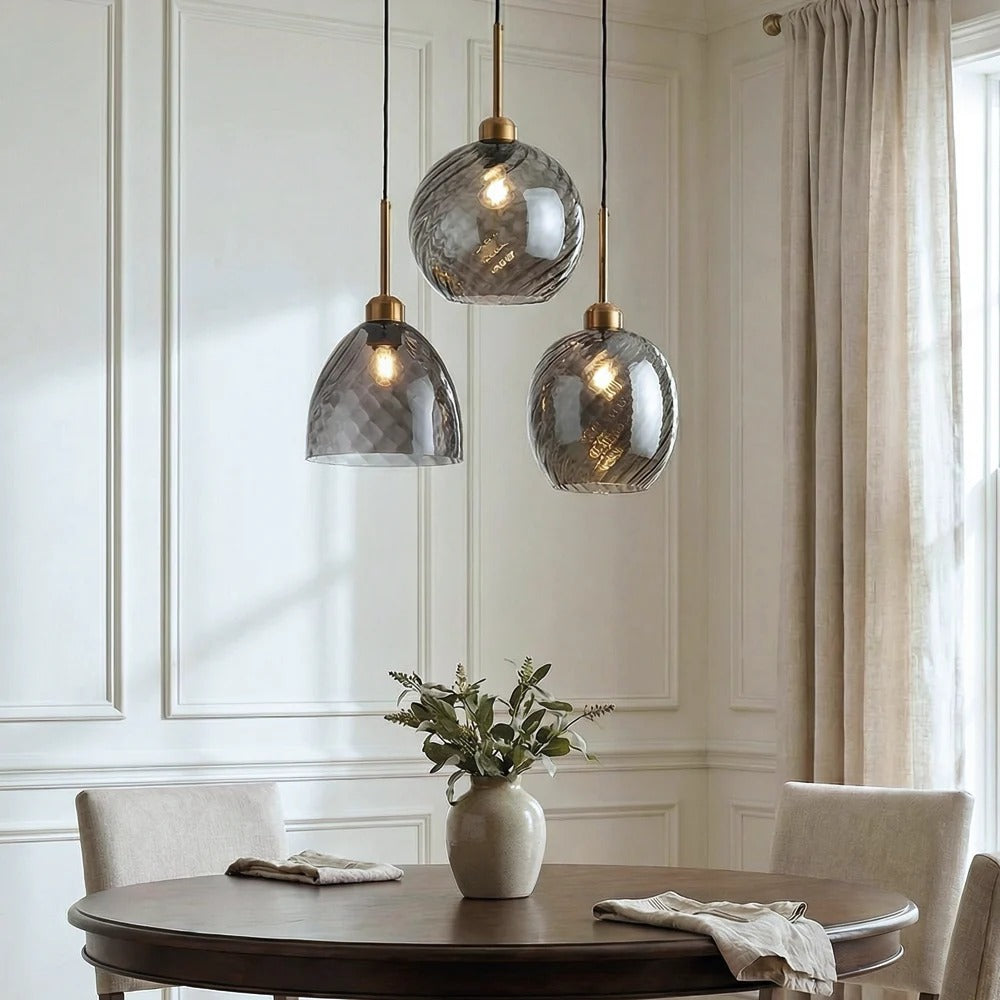 Three Astrid smoked glass pendant lights over a round dining table