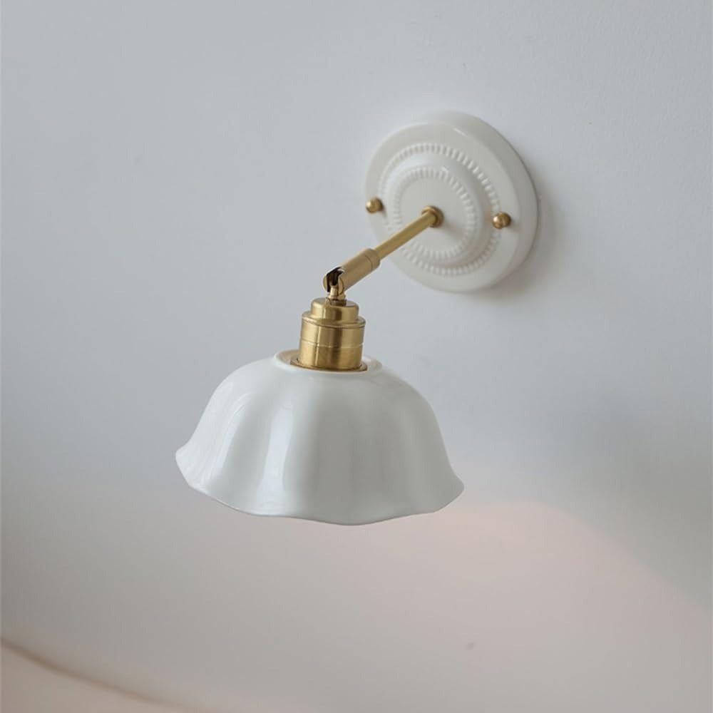 Celia scalloped ceramic wall sconce with a brass-tone arm and white wall plate