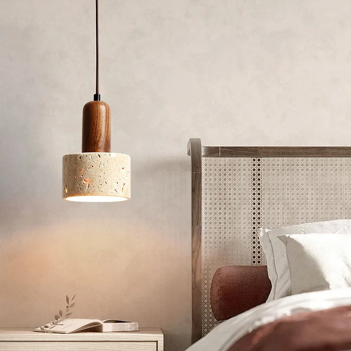 Cora travertine pendant light with a tall walnut neck beside a bed