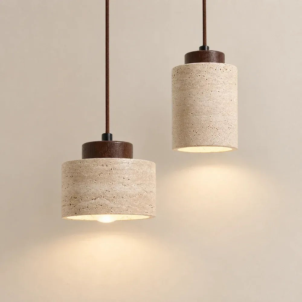 Cora travertine drum and cylinder pendant lights with walnut caps, switched on