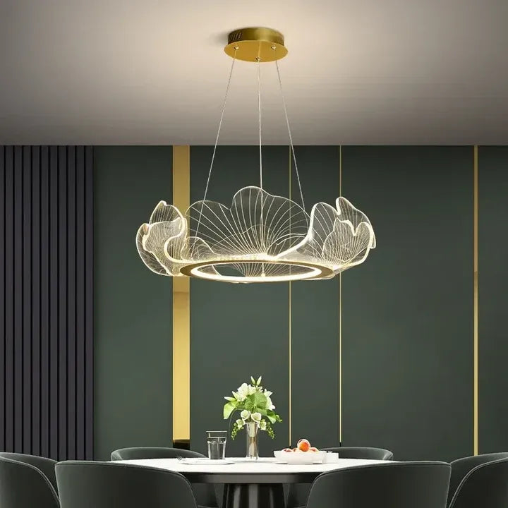 Elara gold ginkgo leaf ring chandelier above a dining table with green upholstered chairs