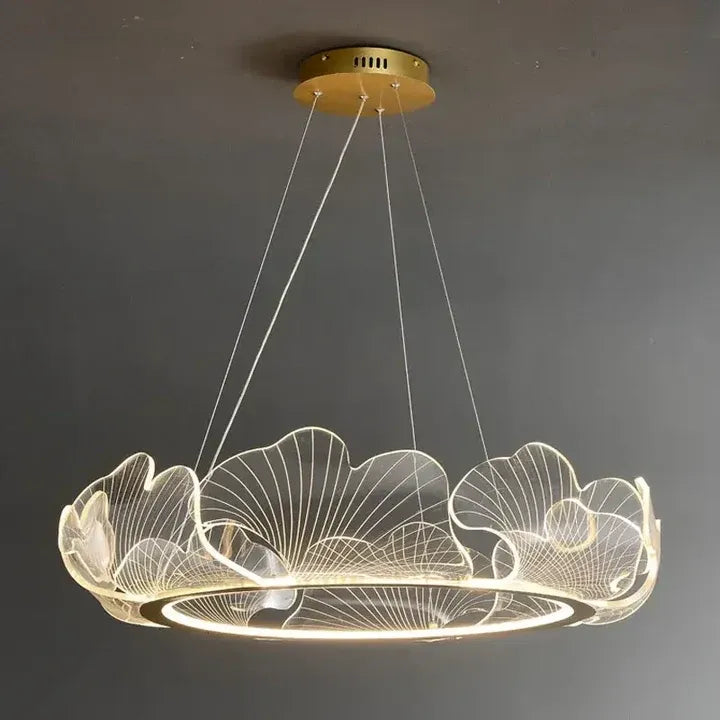 Elara ginkgo leaf chandelier illuminated with warm white light against a gray background