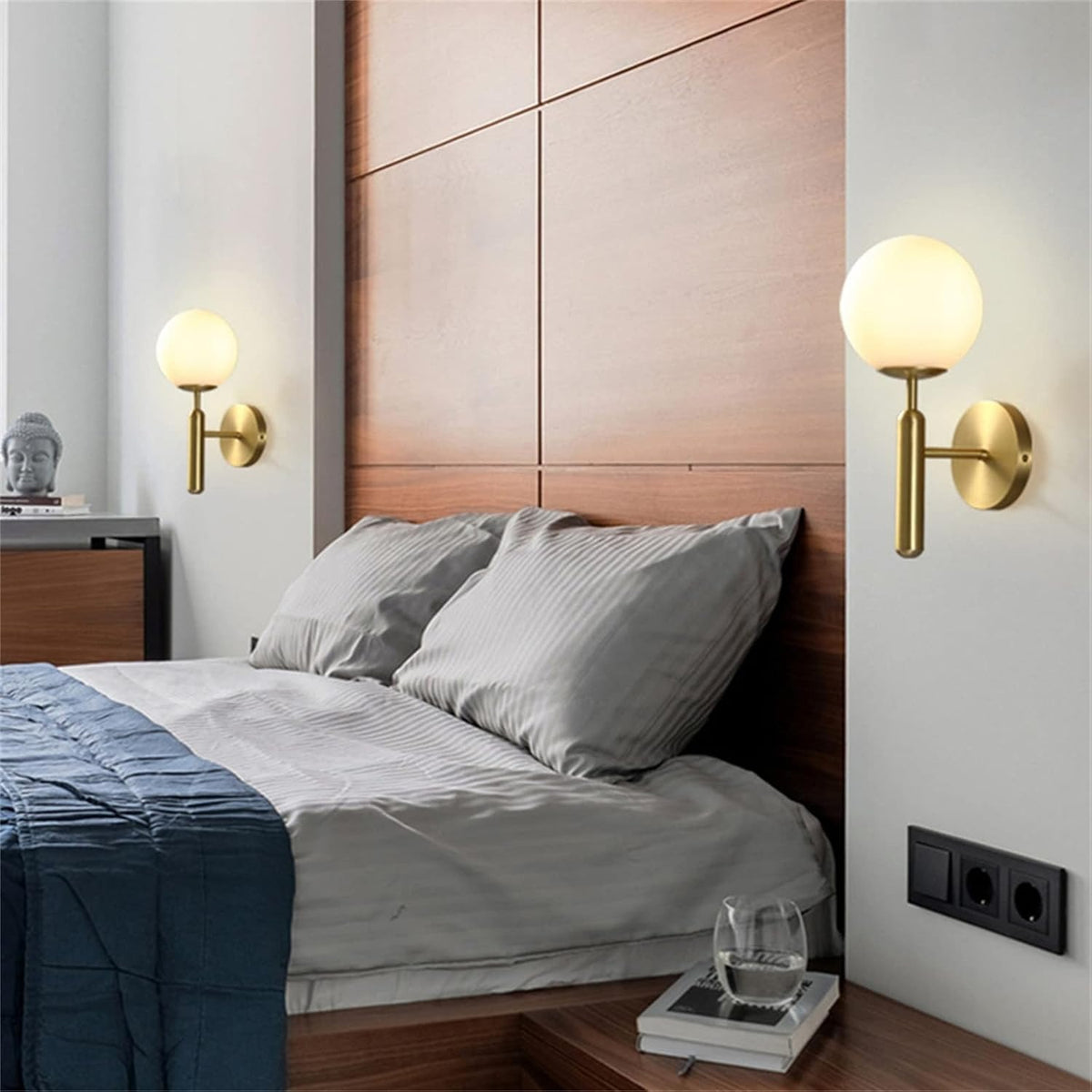 Pair of Elio gold globe wall sconces on each side of a bed