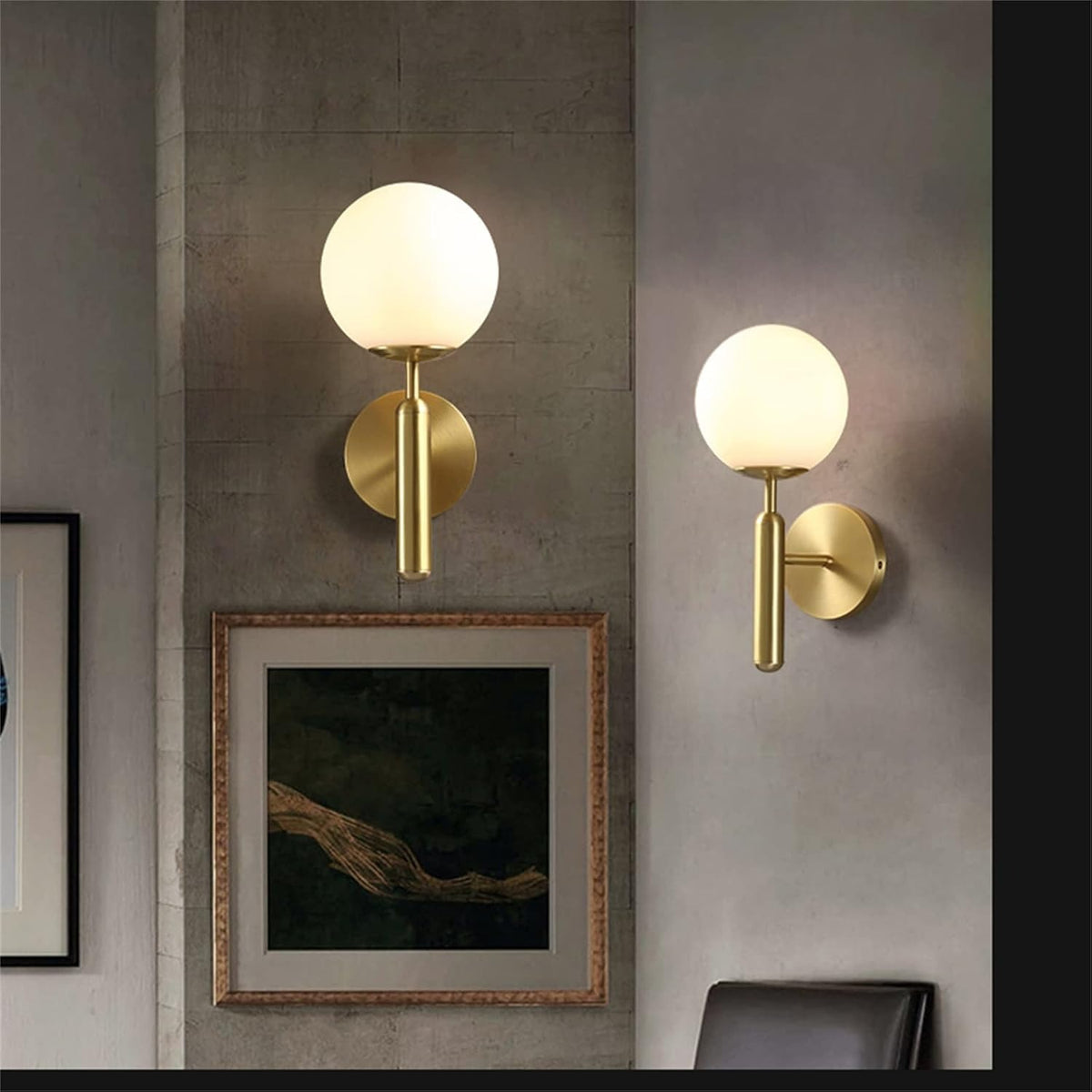 Two Elio gold globe wall sconces on a living room wall
