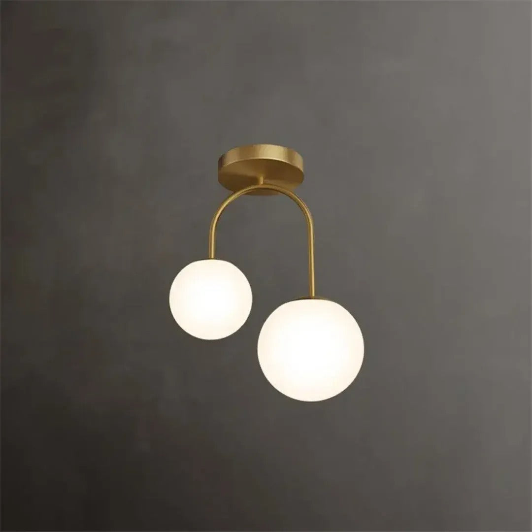 Gemma semi-flush ceiling light with two opal glass globes lit against a dark wall