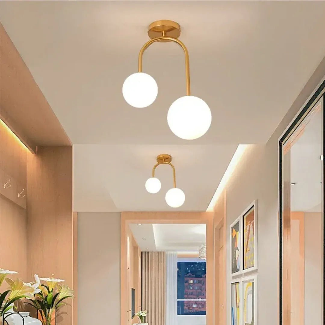 Gemma brass two-globe ceiling lights in a bright hallway
