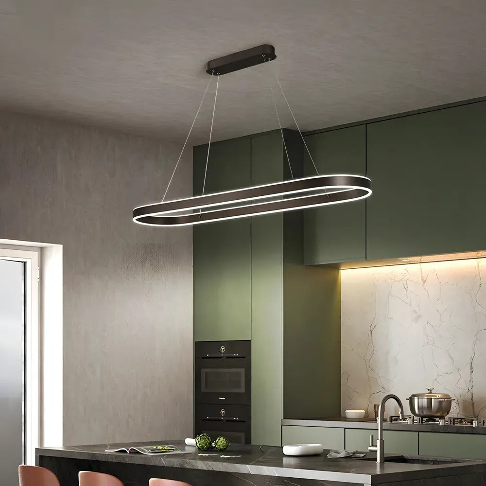 Halo oval LED pendant light in black over a kitchen island with green cabinets
