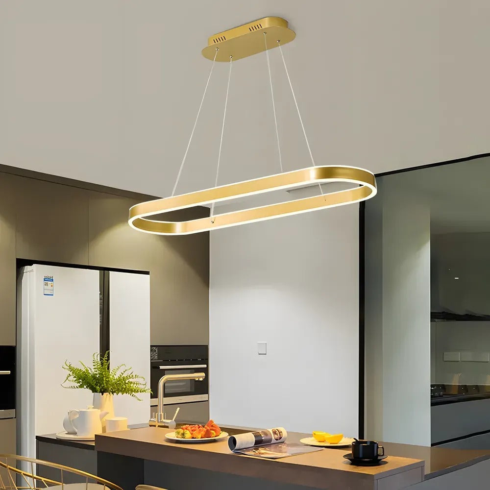 Halo oval LED pendant light in brushed gold over a kitchen counter