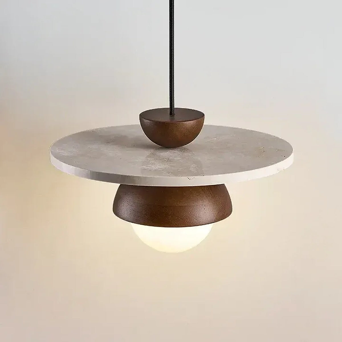 Luna travertine disc catching the warm light from the wood dome and glass globe
