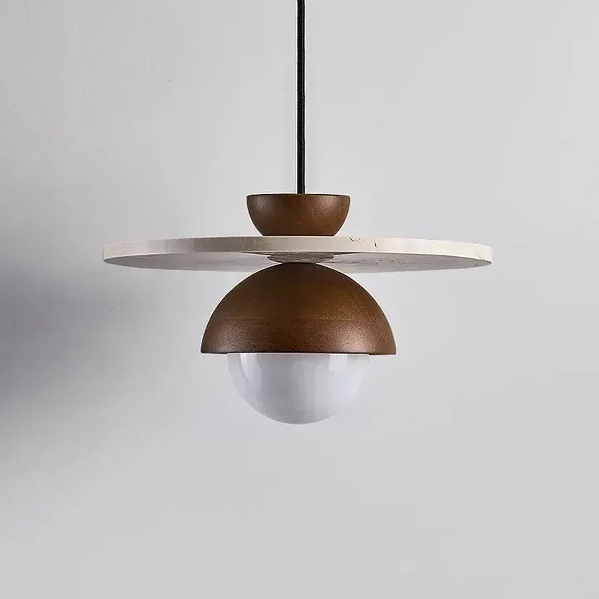 Luna travertine disc pendant light against a gray wall