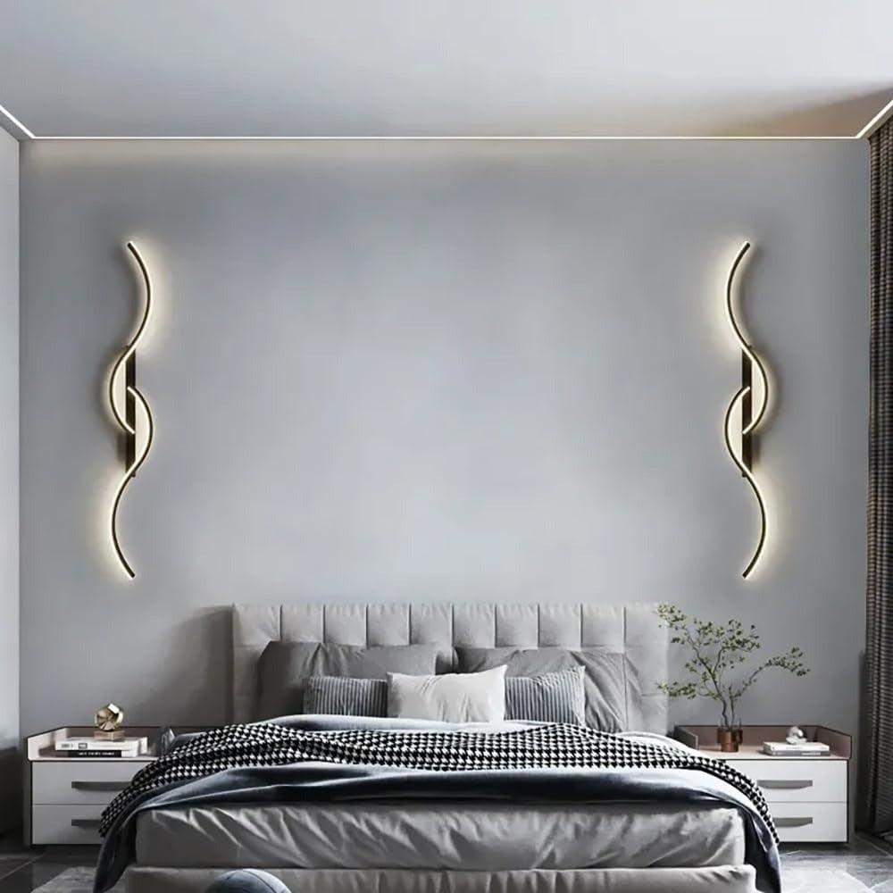 Pair of Lyra black wave LED wall sconces above a bed