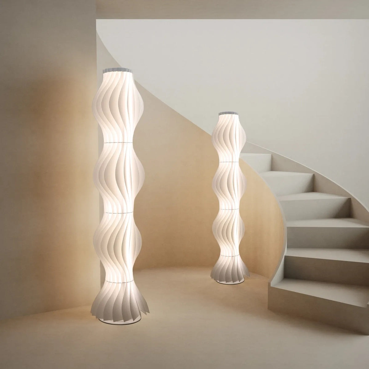 Two Lysia sculptural wave LED floor lamps glowing by a curved staircase