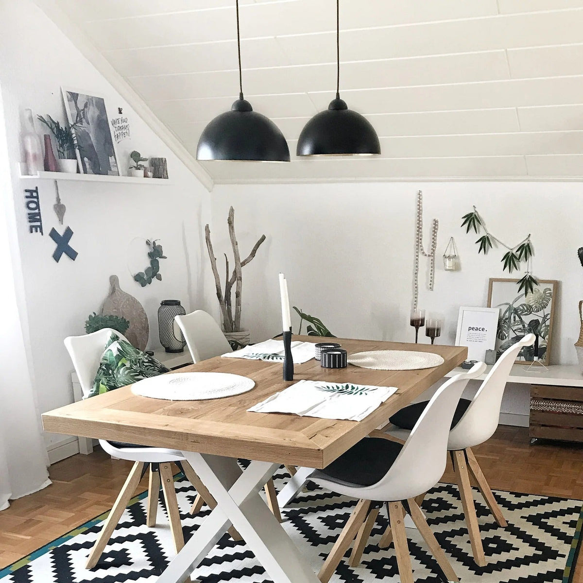 Two Marlow black dome pendant lights over a wood dining table with white chairs