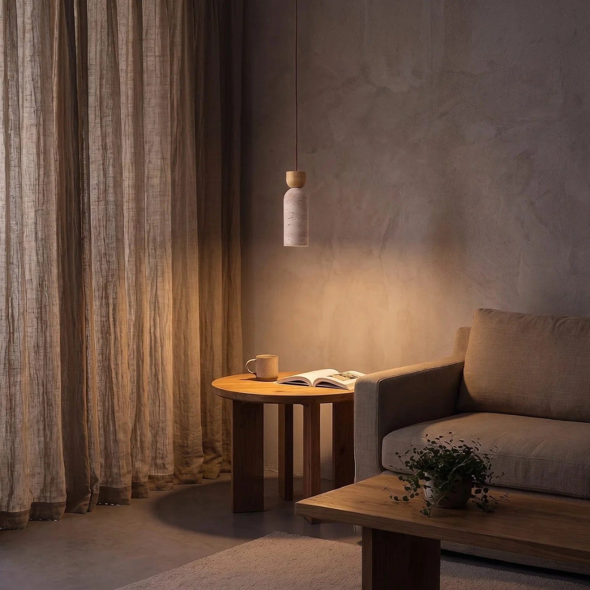 Pia travertine mini pendant light glowing above a side table in a living room