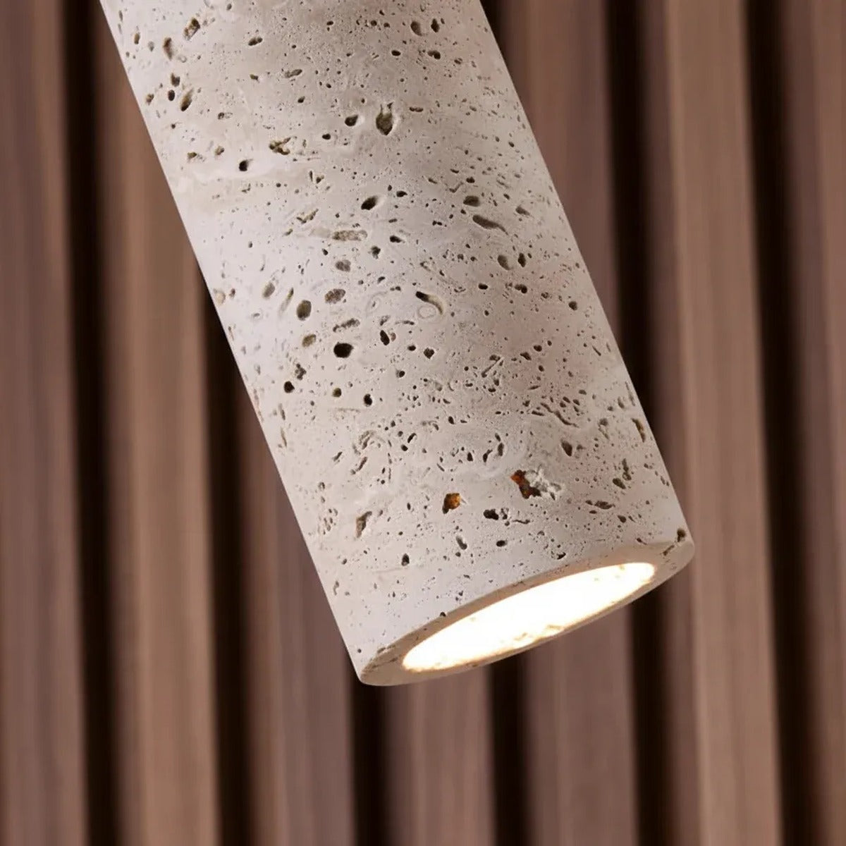 Close-up of the natural travertine pores on the Pia mini pendant shade