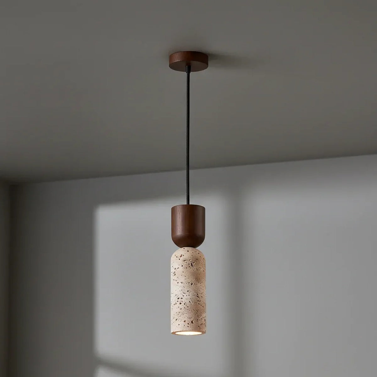Pia travertine mini pendant light with a walnut cap and canopy on the ceiling