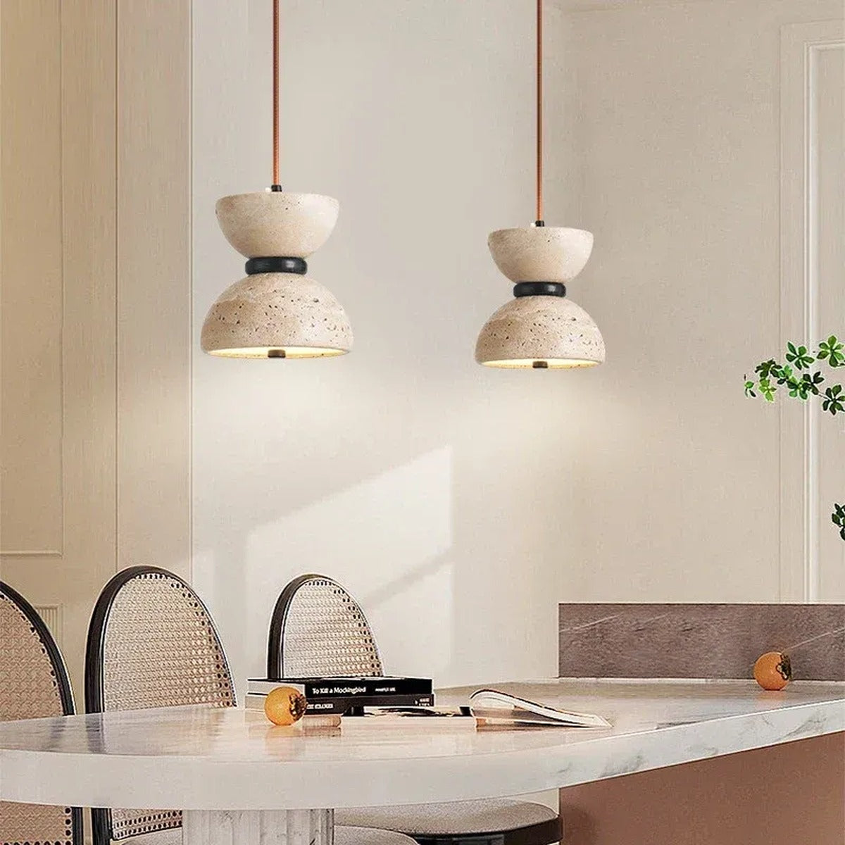 Two Sable travertine hourglass pendant lights above a marble kitchen counter