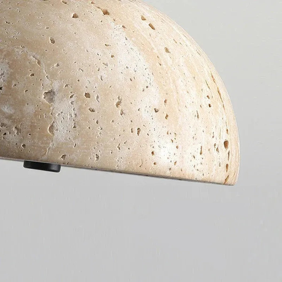 Close-up of the natural travertine pores and texture on the Sable pendant