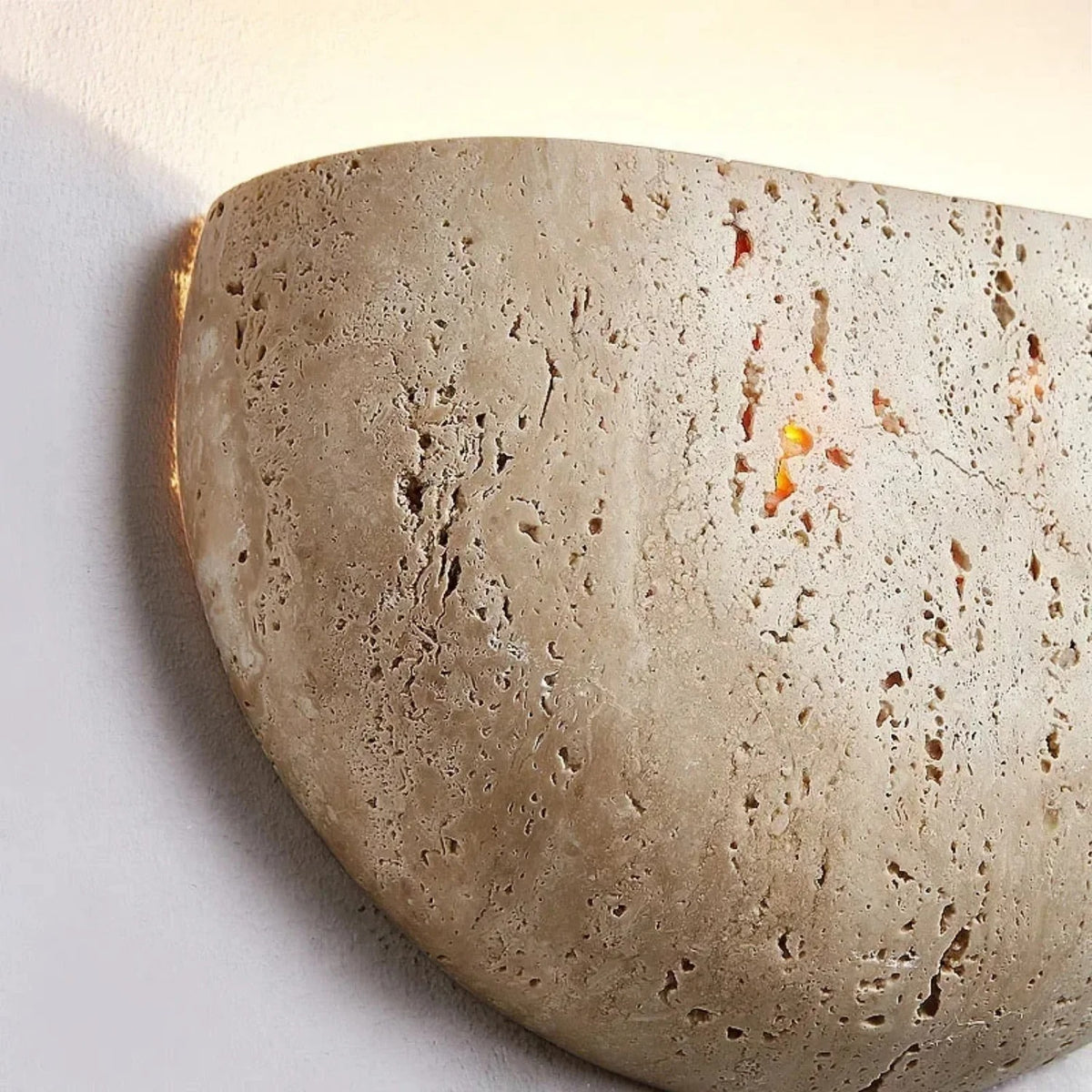 Close-up of the natural travertine pores on the Sora wall sconce