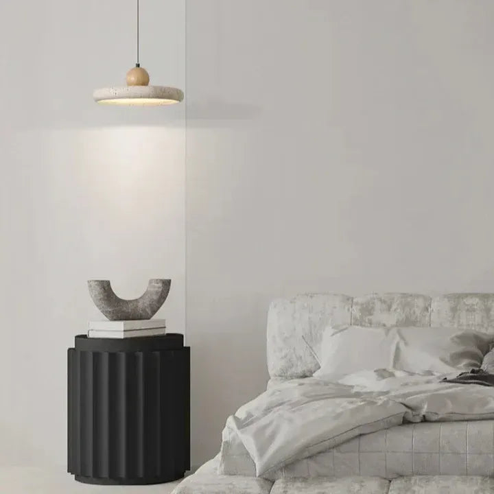 Travertine pendant light beside a bed
