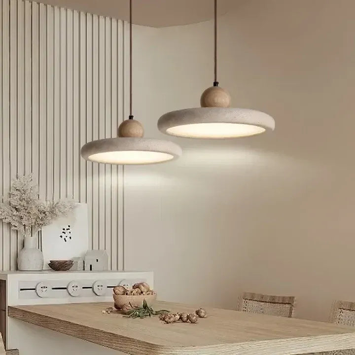 Travertine pendant lights above a wood sideboard