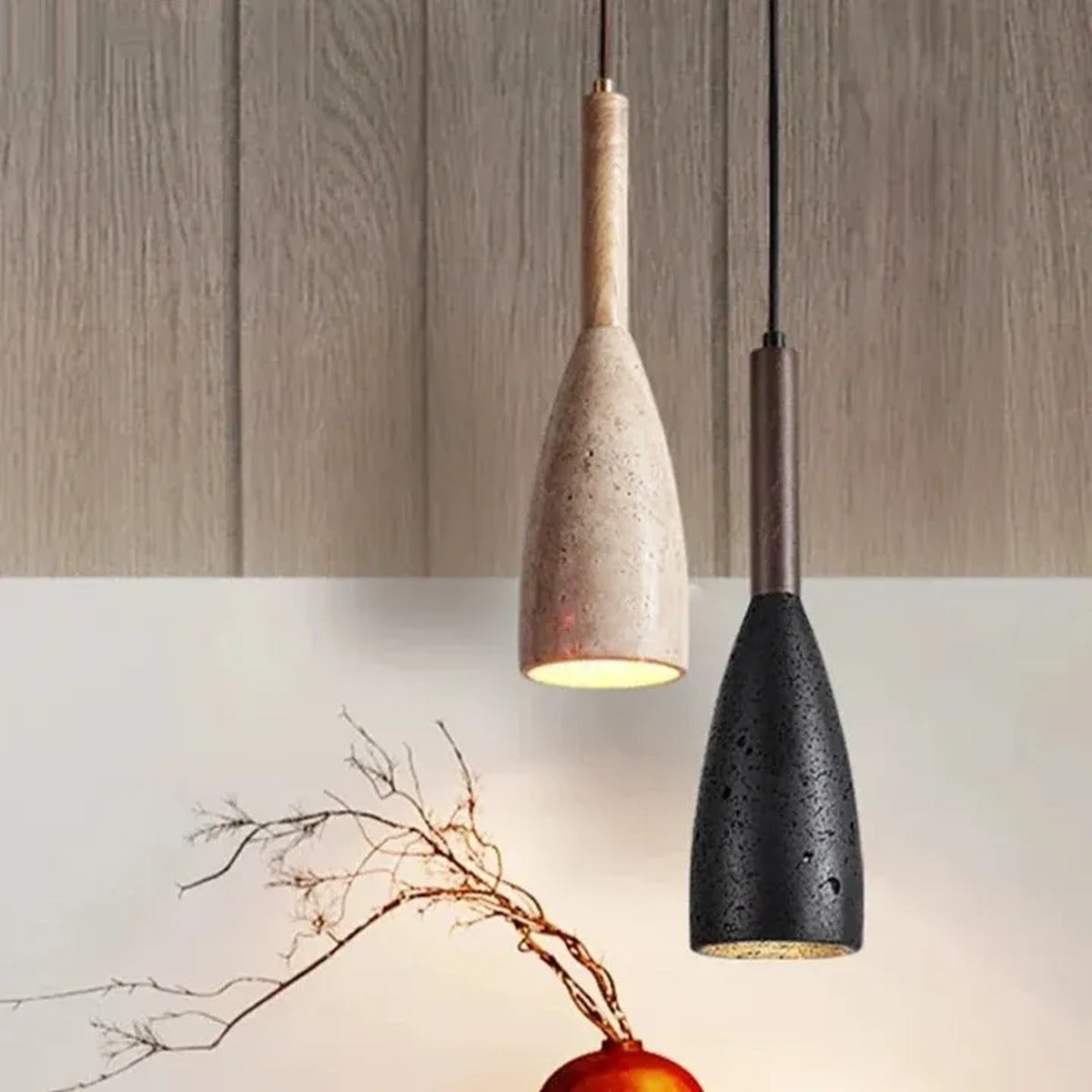 Two Tova bottle pendant lights, travertine with light wood and black stone with walnut, hanging at different heights