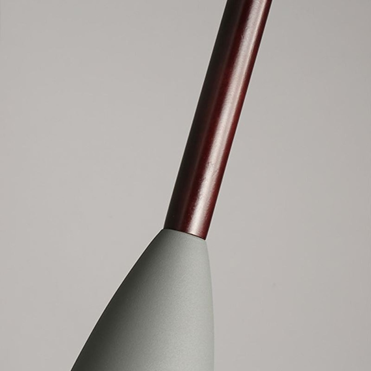 Close-up of the dark wood neck on a gray Vika metal pendant shade
