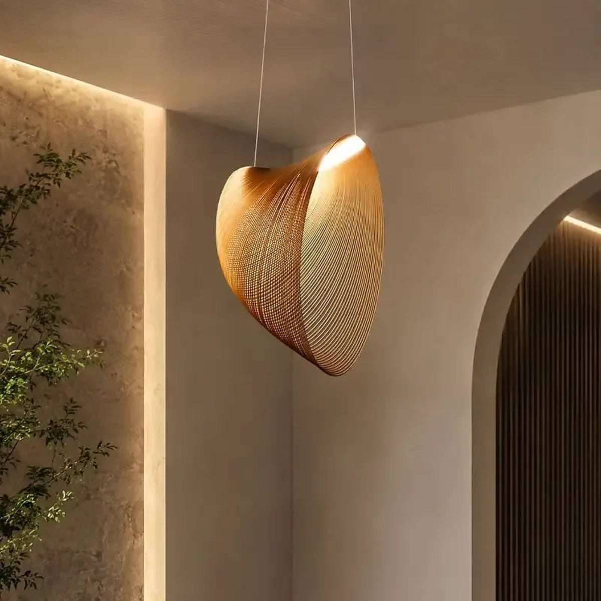 Wren shell LED pendant hanging in a softly lit hallway beside an arched doorway