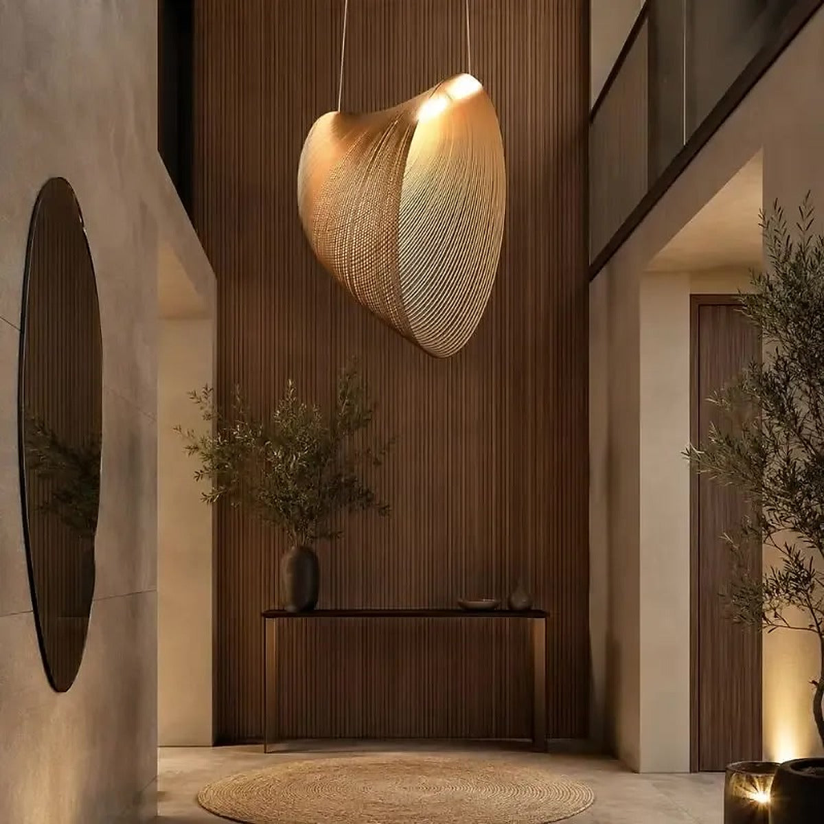 Large Wren shell pendant light hanging in a double-height entry with a wood-slat wall
